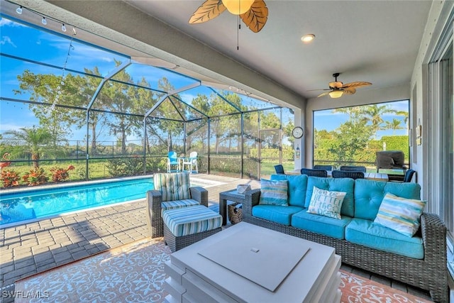 view of patio featuring an outdoor pool, outdoor lounge area, glass enclosure, and a ceiling fan