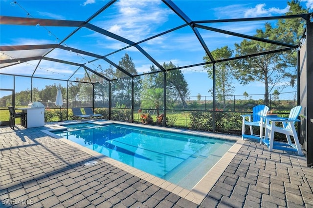 pool with a patio and glass enclosure
