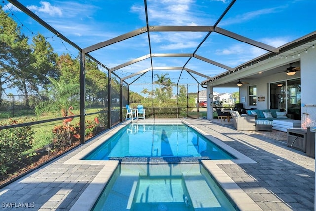 view of swimming pool featuring ceiling fan, a pool with connected hot tub, outdoor lounge area, glass enclosure, and a patio area