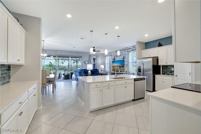 kitchen featuring tasteful backsplash, recessed lighting, appliances with stainless steel finishes, a sink, and open floor plan