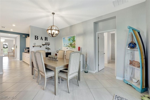 dining space featuring light tile patterned floors, a notable chandelier, baseboards, and visible vents