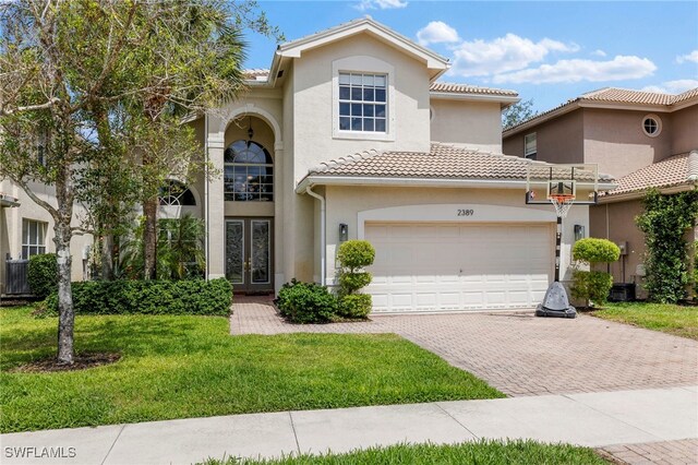 2389 Leafshine Ln, Naples, FL 34119 - view of front of home featuring french doors, stucco siding, a tile roof, and decorative driveway