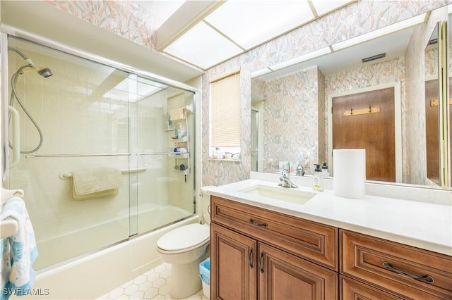 full bathroom with toilet, wallpapered walls, vanity, and combined bath / shower with glass door