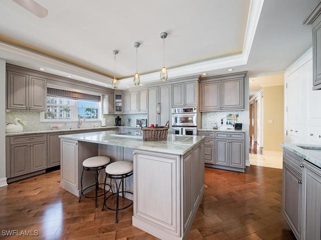 1255 Gulf Shore Blvd N Unit 3N, Naples, FL 34102 - kitchen with gray cabinetry, a raised ceiling, double oven, a center island, and recessed lighting