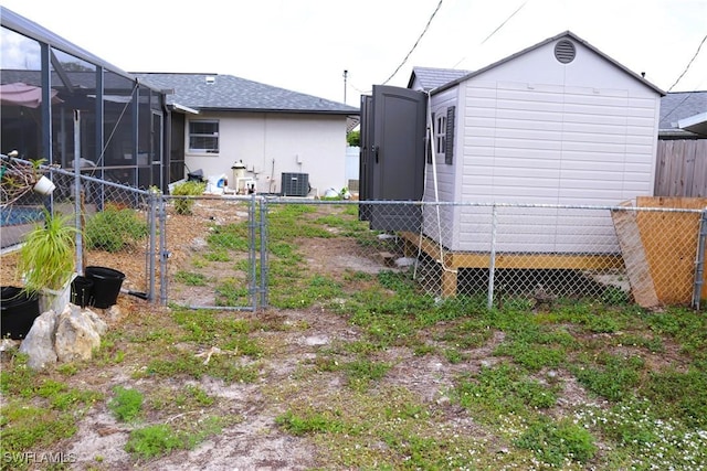 18254 Lowe Dr, Fort Myers, FL 33967 - view of yard with an outdoor structure, fence, glass enclosure, and central AC