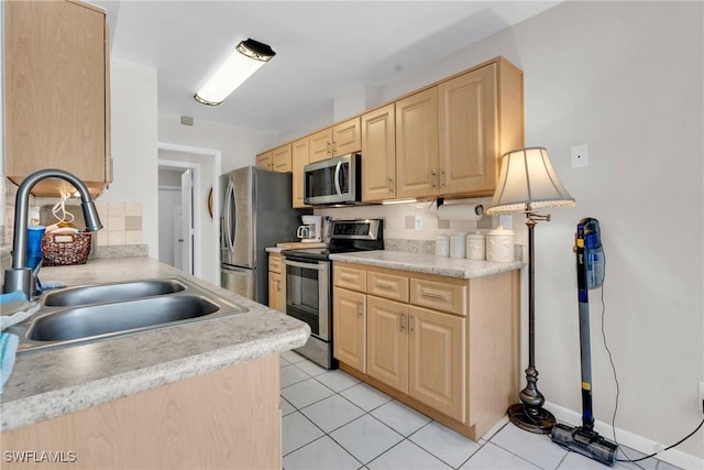 1514 Canal St, Lehigh Acres, FL 33936 - kitchen featuring decorative backsplash, light brown cabinetry, a sink, and appliances with stainless steel finishes