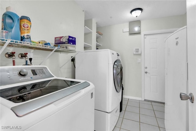 1514 Canal St, Lehigh Acres, FL 33936 - laundry area featuring light tile patterned floors, baseboards, washer and dryer, and laundry area