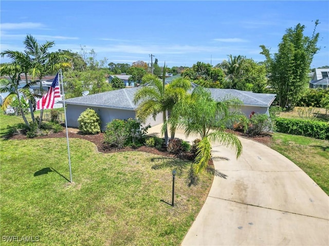 1514 Canal St, Lehigh Acres, FL 33936 - view of front of house featuring stucco siding, a front lawn, and concrete driveway