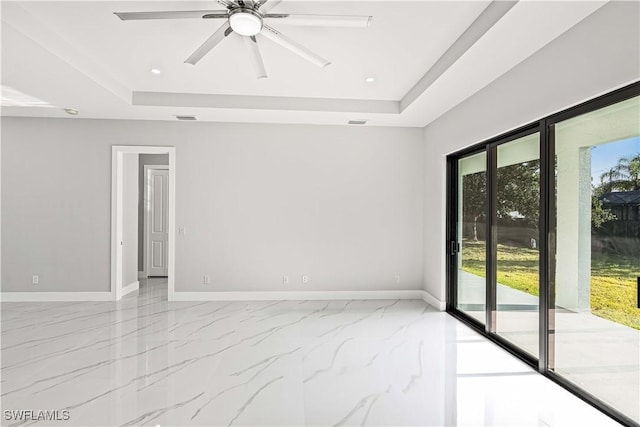 1819 NW 19th Ave, Cape Coral, FL 33993 - empty room with a ceiling fan, marble finish floor, a raised ceiling, and baseboards