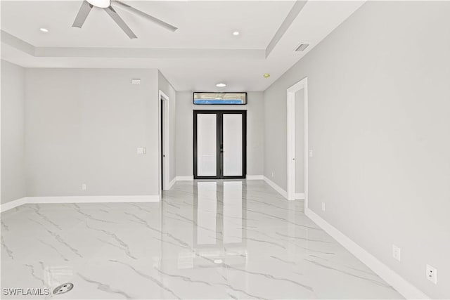 1819 NW 19th Ave, Cape Coral, FL 33993 - empty room with baseboards, a ceiling fan, a tray ceiling, and marble finish floor