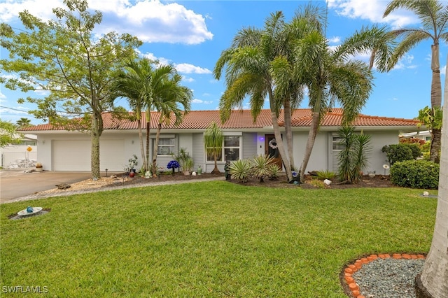 single story home featuring a front yard, a tiled roof, a garage, concrete driveway, and stucco siding