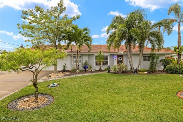 ranch-style home featuring a garage, stucco siding, a tile roof, a front lawn, and driveway