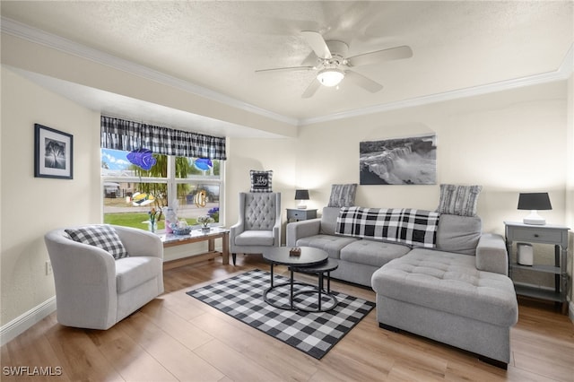 living room with baseboards, ceiling fan, a textured ceiling, crown molding, and wood finished floors