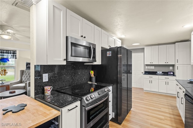 kitchen with light wood-style flooring, decorative backsplash, white cabinetry, and stainless steel appliances