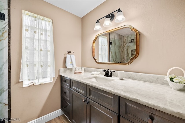 bathroom featuring a shower and vanity