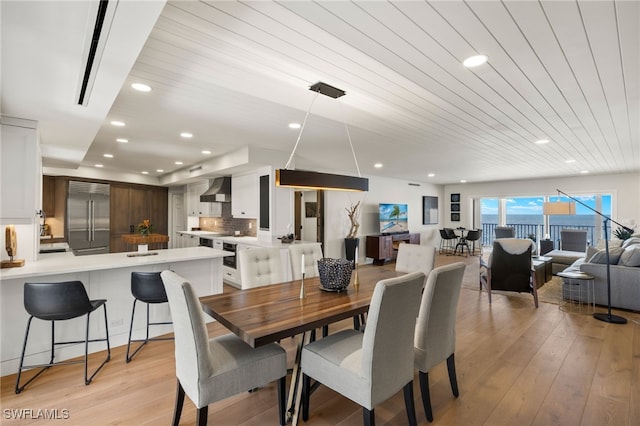 dining area with light wood-style floors, wooden ceiling, and recessed lighting