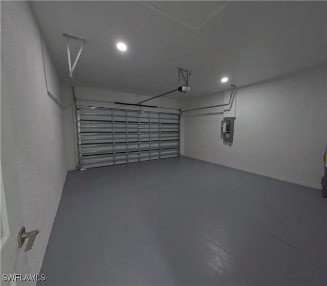 garage featuring a garage door opener, electric panel, and recessed lighting