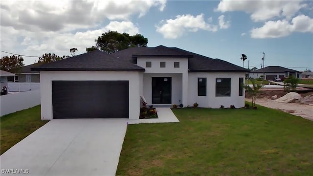 prairie-style house featuring a garage, stucco siding, a front yard, a shingled roof, and driveway