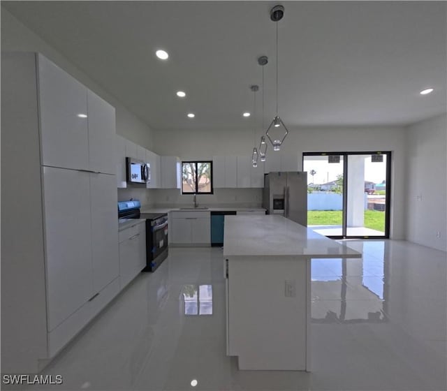 kitchen featuring white cabinets, modern cabinets, a sink, appliances with stainless steel finishes, and recessed lighting