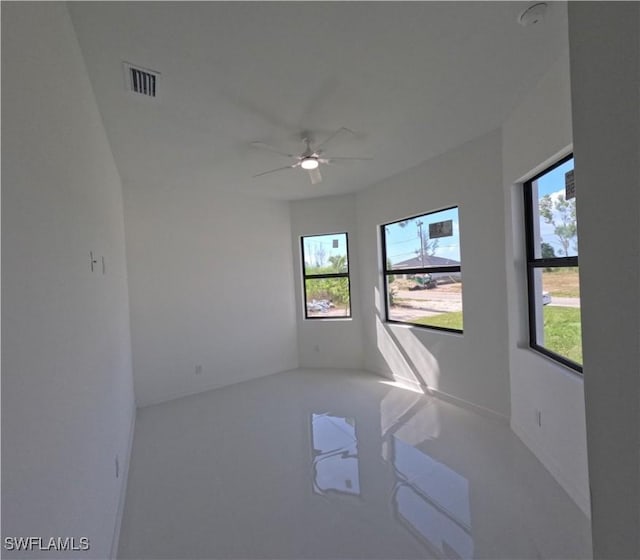 unfurnished room featuring visible vents and a ceiling fan