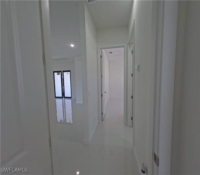 hall featuring tile patterned floors and baseboards