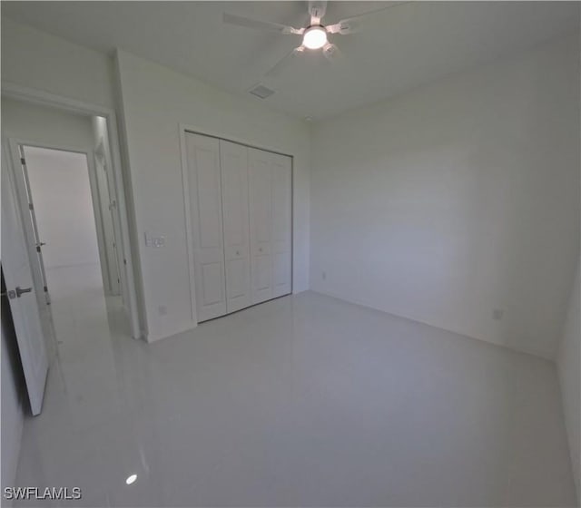 unfurnished bedroom featuring tile patterned floors, a closet, a ceiling fan, and visible vents