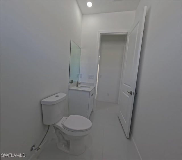 bathroom with toilet, vanity, baseboards, and tile patterned flooring