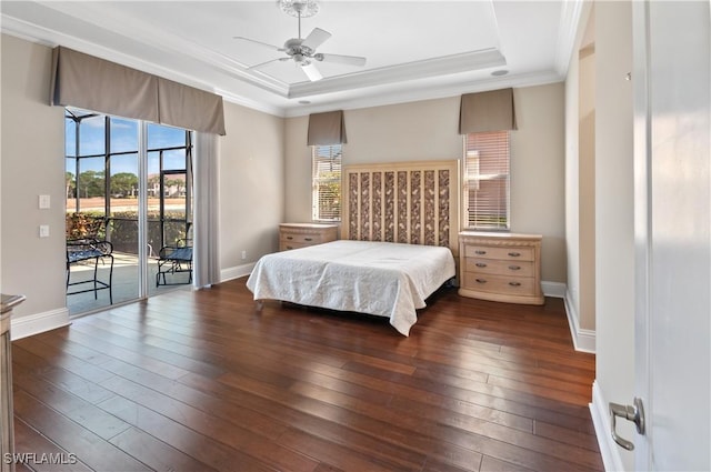 bedroom with baseboards, ornamental molding, a raised ceiling, access to exterior, and dark wood finished floors
