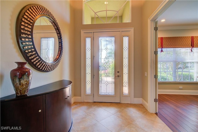 foyer entrance featuring light tile patterned floors and baseboards