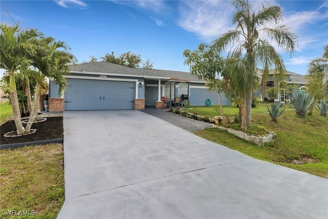 ranch-style house with concrete driveway, a garage, stucco siding, and a front yard