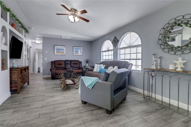 living room with light wood-type flooring, a ceiling fan, and baseboards