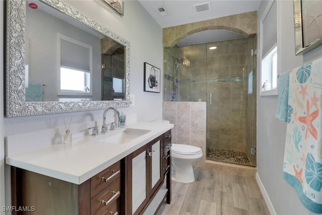 bathroom with a wealth of natural light, toilet, visible vents, and a stall shower
