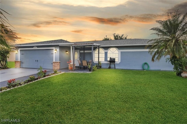view of front of property with a yard, an attached garage, and stucco siding
