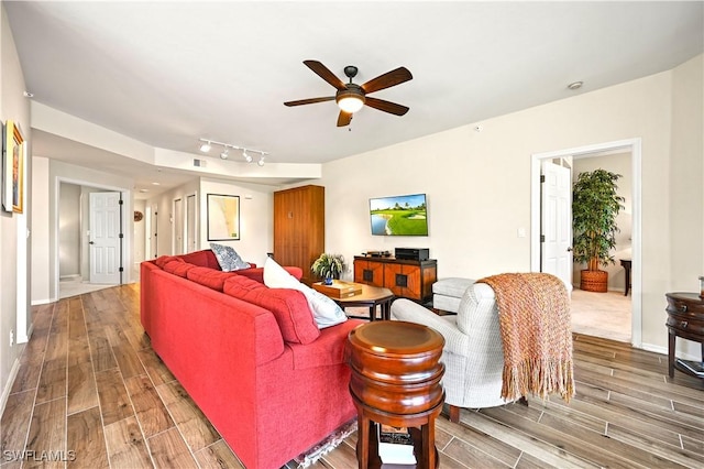 living room featuring light wood finished floors, ceiling fan, and baseboards