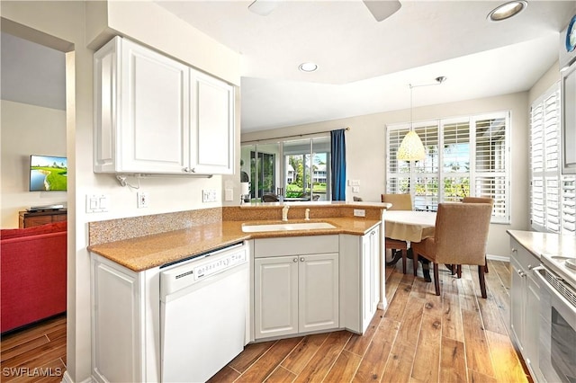 kitchen with white dishwasher, a sink, light wood-style floors, stainless steel range with electric stovetop, and recessed lighting