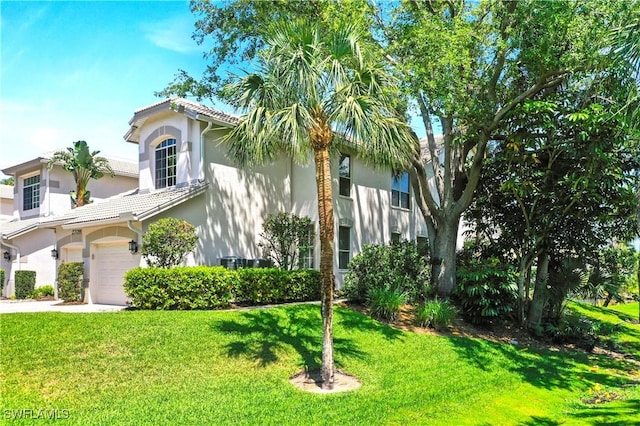 view of front of property with a garage, stucco siding, a front lawn, driveway, and a tile roof