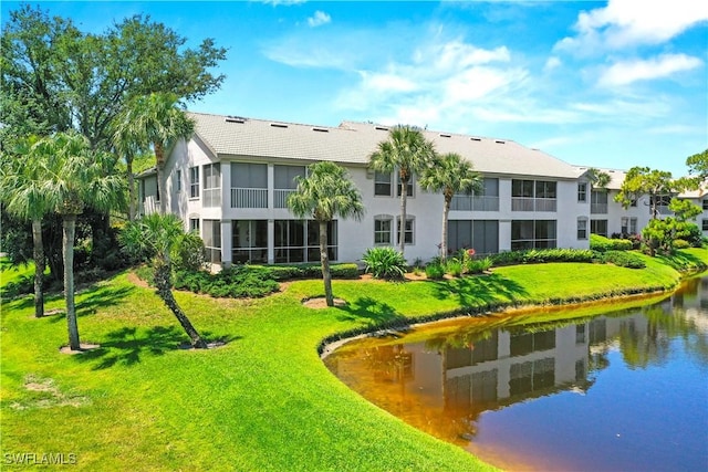 view of property's community featuring a lawn and a water view