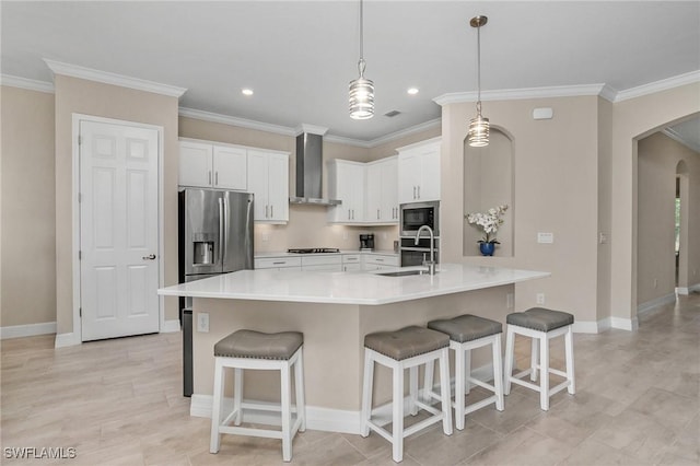 13504 Blue Bay Cir, Miromar Lakes, FL 33913 - kitchen featuring crown molding, wall chimney exhaust hood, stainless steel appliances, arched walkways, and a sink