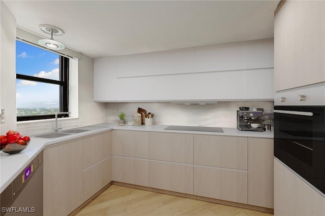 kitchen featuring stainless steel oven, modern cabinets, and light countertops