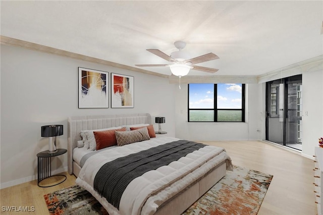 bedroom with crown molding, wood finished floors, a ceiling fan, and baseboards