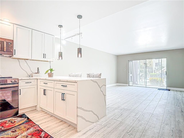 1320 Blue Point Ave Unit 2, Naples, FL 34102 - kitchen featuring stainless steel appliances, light wood-style flooring, a peninsula, open floor plan, and white cabinets