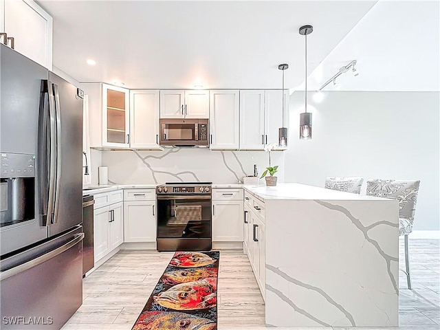1320 Blue Point Ave Unit 2, Naples, FL 34102 - kitchen with stainless steel appliances, a peninsula, light stone countertops, white cabinets, and recessed lighting