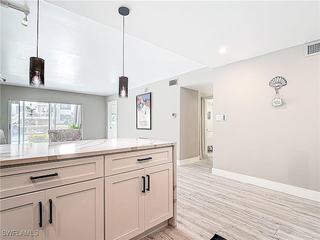 1320 Blue Point Ave Unit 2, Naples, FL 34102 - kitchen with light wood-style flooring, light stone counters, baseboards, and decorative light fixtures