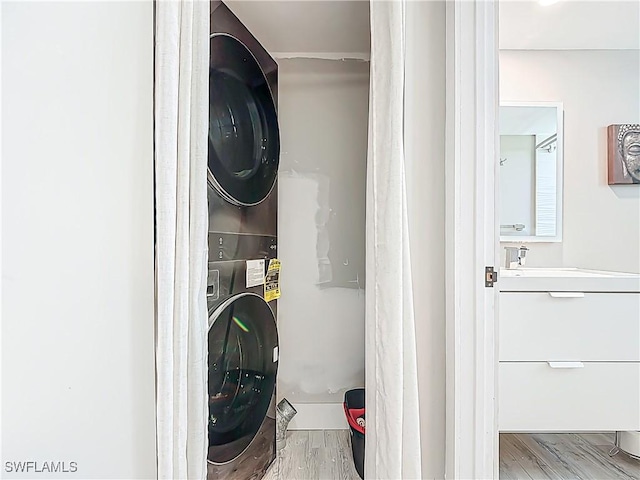 1320 Blue Point Ave Unit 2, Naples, FL 34102 - clothes washing area with estacked washer and dryer and wood finished floors