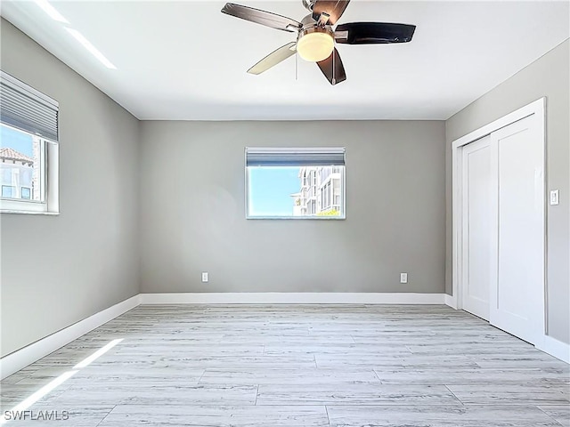 1320 Blue Point Ave Unit 2, Naples, FL 34102 - unfurnished bedroom featuring multiple windows, light wood-type flooring, baseboards, and ceiling fan