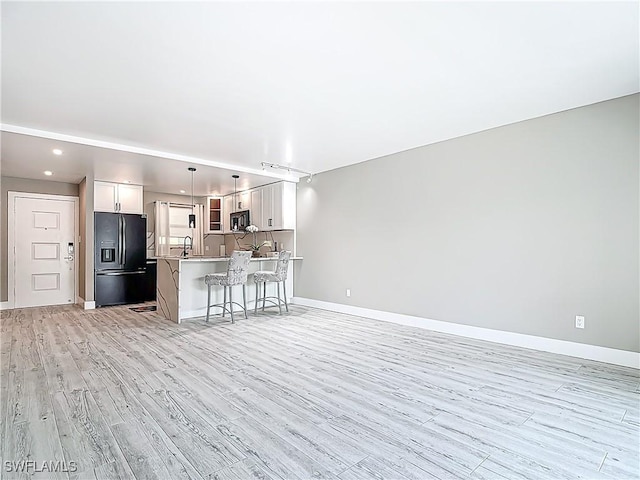 1320 Blue Point Ave Unit 2, Naples, FL 34102 - living room with light wood finished floors, baseboards, and recessed lighting