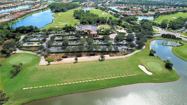 drone / aerial view featuring golf course view, a residential view, and a water view
