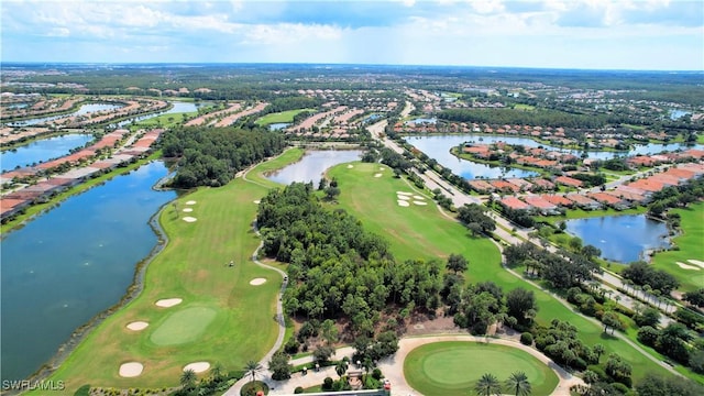 drone / aerial view with view of golf course, a residential view, and a water view