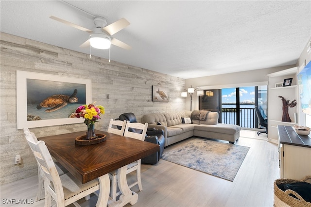 4835 Bonita Beach Rd Unit 407, Bonita Springs, FL 34135 - living room featuring light wood-style flooring, a textured ceiling, an accent wall, and a ceiling fan