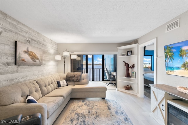 4835 Bonita Beach Rd Unit 407, Bonita Springs, FL 34135 - living area featuring a textured ceiling, visible vents, and light wood-style floors